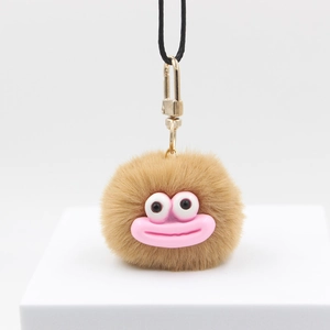 Whimsical khaki plush pompom monster charm with large pink lips and gold lobster clasp
