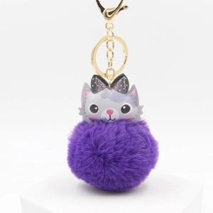 Detail of cute cat plush ball keychain with purple fur and golden metal lobster clasp