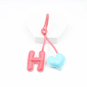 Pink letter H and blue heart PU leather charms for keychains and bags on white stand