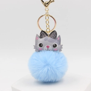 Cute plush kitten keychain with light blue pompom and golden lobster clasp on display stand