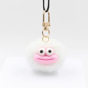 Detail shot of a white plush ball keychain featuring a pink big mouth and large cartoon eyes