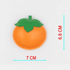 Faux leather persimmon bag charm with green leaf detail, 7cm wide by 6.8cm tall size