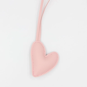 Pink heart leather keychain with long strap and visible stitching on white background