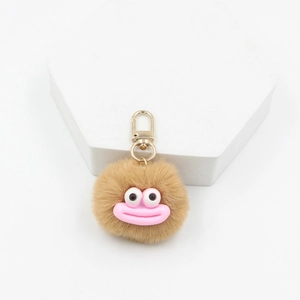 Macro detail of brown plush monster keychain with large eyes and pink sausage lips