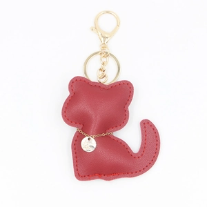 Porte-clés chat mignon en cuir PU rouge avec fermoir doré et anneau sur fond blanc neutre