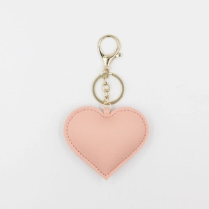 Porte-clés cœur en cuir PU rose mignon avec clip en métal doré sur fond blanc