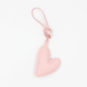 Close-up of pink heart-shaped leather keychain with fine stitching and soft lychee texture