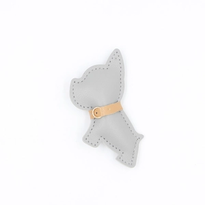 Dettaglio del portachiavi a forma di bulldog francese in pelle PU grigia con fibbia dorata