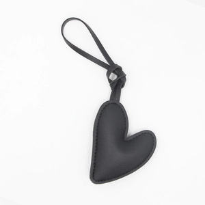 Close-up of black heart-shaped leather keychain with detailed stitching and cord