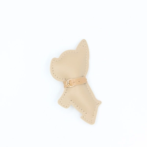 Dettaglio del portachiavi in pelle di Bulldog Francese beige con cuciture fini e fibbia d'oro