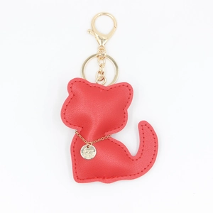 Détail d'un porte-clés chat en similicuir rouge avec chaîne dorée et fermoir mousqueton