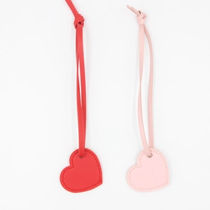 Simple red and pink heart leather keychains with stitched edges on white background