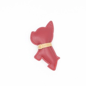 Dettaglio del portachiavi bulldog francese in pelle rosso scuro con cuciture fini