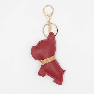 Dettaglio del portachiavi a forma di cane in pelle PU rossa con gancio dorato e cuciture