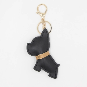 Dettaglio ravvicinato di un portachiavi a forma di cane in pelle PU nera con finiture oro