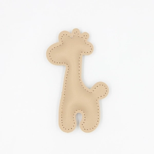 Detailed close-up of brown leather giraffe keychain with precise stitching on white background
