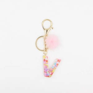 Détail du porte-clés pompon rose et lettre V avec paillettes de cœur colorées