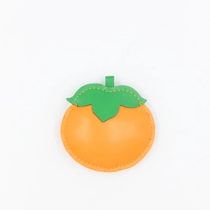 Handmade orange persimmon leather charm with green leaves and premium stitching detail