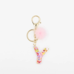 Détail du pompon en fausse fourrure rose et porte-clés lettre Y en résine avec paillettes