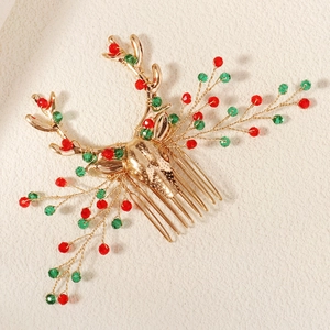 Detail view of a gold Christmas reindeer hair comb with red and green crystal beads