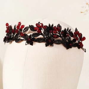 Gothic headband detail featuring black metallic leaves and deep red faceted crystals