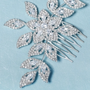 Detailed macro view of silver bridal hair comb with cubic zirconia floral leaf patterns