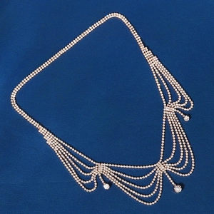Detail of exotic rhinestone tassel head chain with gold finish and sparkling crystal fringe