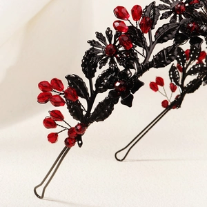 Detail of gothic black metal headband with dark red faceted crystals and floral elements