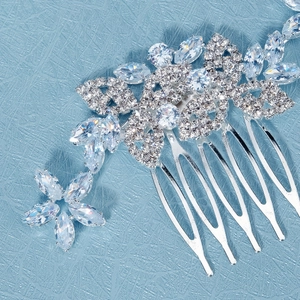 Close-up of bridal silver hair comb with crystal leaves and rhinestone flower details