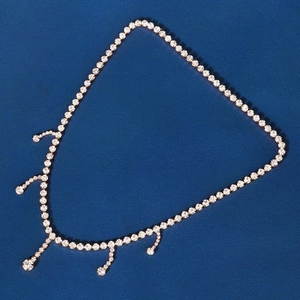 Detailed close-up of golden fringe hair chain with sparkling rhinestones and tassels