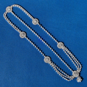 Detailed macro view of layered rhinestone body chain with shimmering tassels and round accents