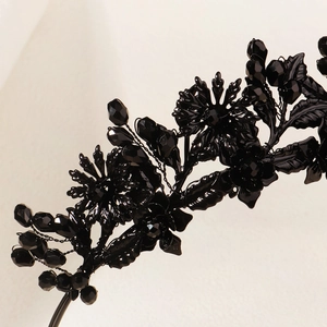 Macro detail of gothic black flower headband with crystals and metallic leaf textures