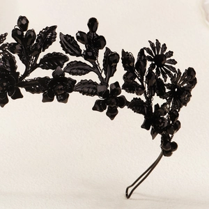 Macro detail of gothic black crystal beads and metal flower petals on a headband