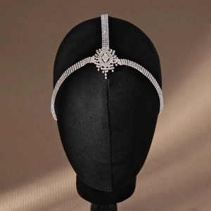 Macro detail of silver rhinestone head chain with floral motif and fringed tassels
