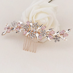 Gros plan détaillé d'un peigne à cheveux de mariée avec strass roses et motifs de feuilles