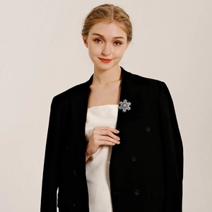 Sparkling snowflake brooch in silver finish with rhinestones on a black suit lapel
