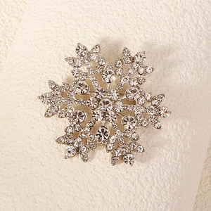 Macro view of silver snowflake brooch with sparkling crystal rhinestones and alloy base