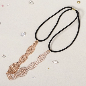 Détail d'un serre-tête ondulé en or rose serti de strass avec bande élastique noire