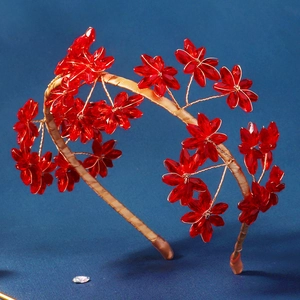 Détail du serre-tête fleurs en cristal rouge avec broderie artisanale en fil doré