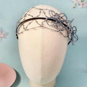 Detailed view of handmade mesh headband with blue crystal beads on a model head