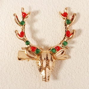 Close-up of golden reindeer antler hair clip with red and green crystal beads