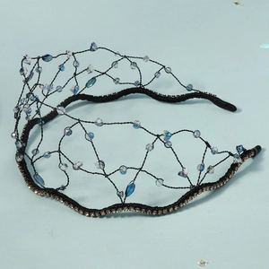Détail macro du serre-tête en maille tissée main avec perles de cristal bleu