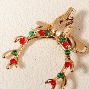 Detail of Christmas reindeer hair clip with red and green crystal beads on gold metal