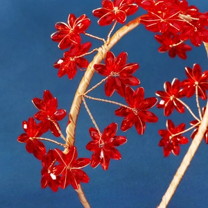 Vue détaillée d'un serre-tête artisanal avec fleurs en cristal rouge et fil doré
