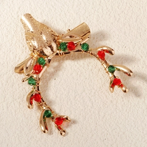 Close-up of golden reindeer antler hair clip with festive red and green crystal beads