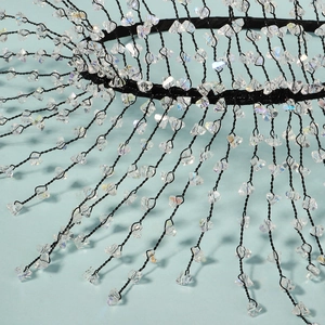 Close-up of handmade black wire headband with faceted crystal beads and mesh weaving