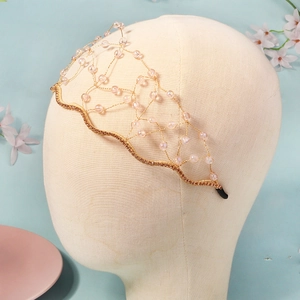 Détail d'un serre-tête en maille dorée tissée à la main avec perles en cristal rose