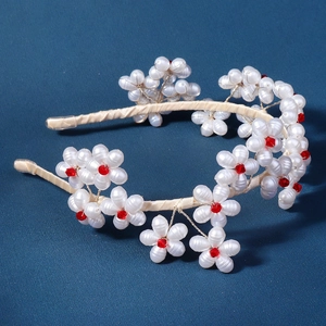 Handmade bridal headband with white pearl flowers and red crystals on beige satin