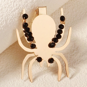 Détail de la pince à cheveux araignée dorée avec perles de cristal noir et fil enroulé