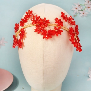 Détail d'un serre-tête fleurs en cristal rouge fait main avec fil doré et perles